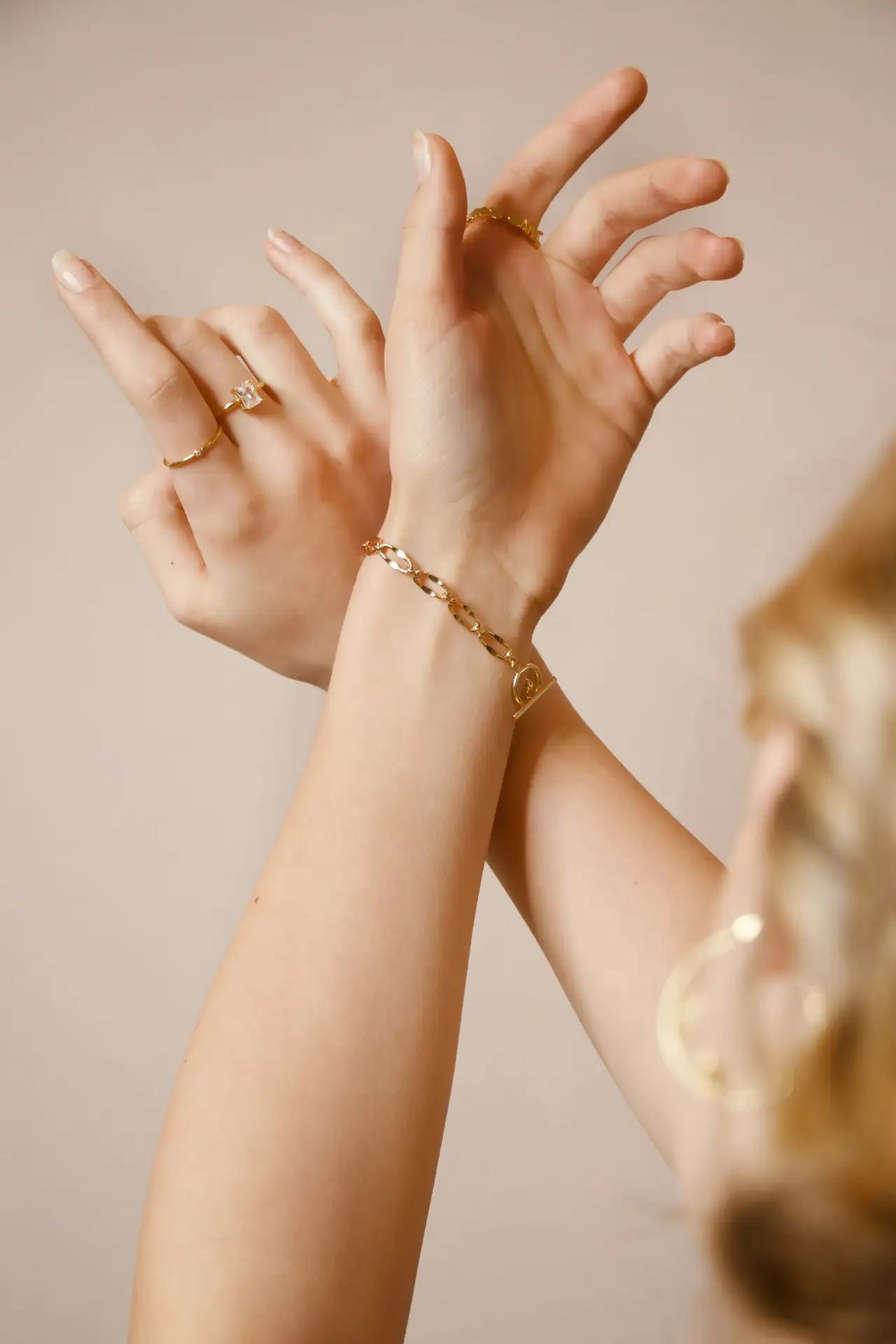Two wrists with fine gold bracelets