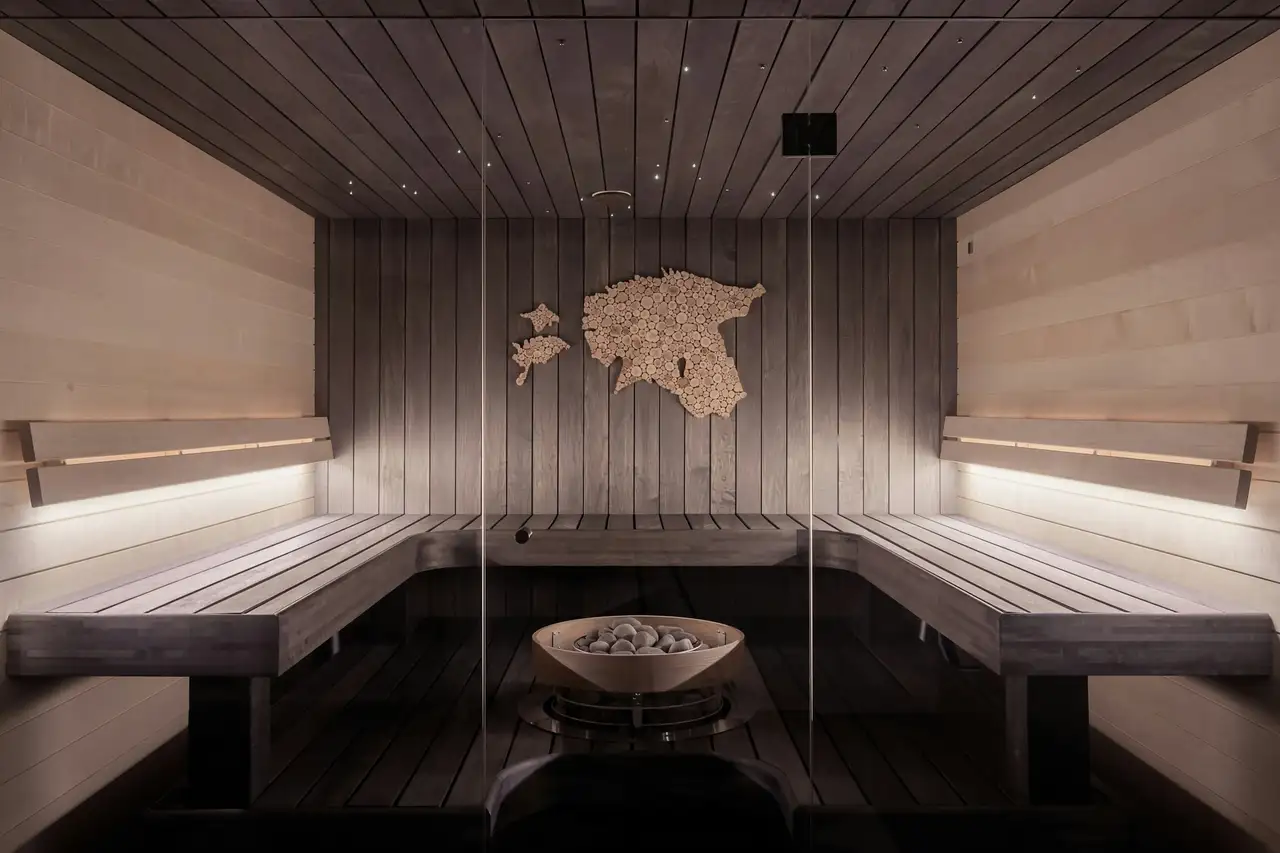 A wooden steam room with a stone heater