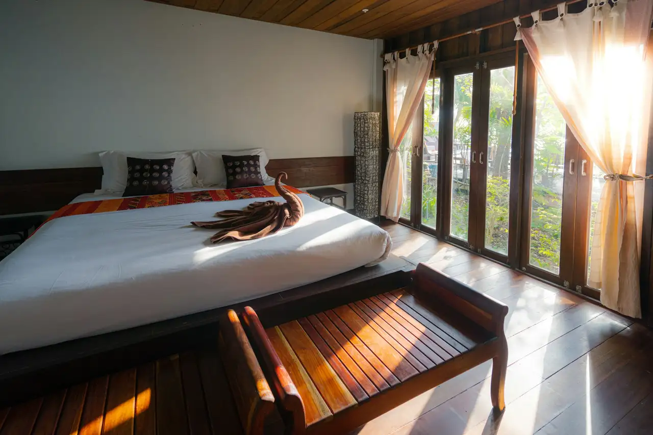 A treatment room with dark wood, daybed and tall windows